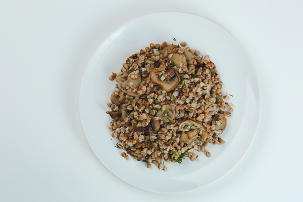 buckwheat with mushrooms in plate isolated on white background - Фаршированные кальмары, постный стол