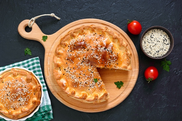 cabbage pie tasty freshly baked homemade vegetable pie with cabbage spinach eggs and sesame seeds on a wooden board top view - Пирог с капустой постный