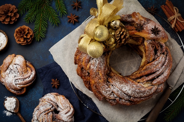 christmas pie roll with cinnamon and powdered sugar on a dark old concrete or stone surface - Пирог "Рождественский венок"