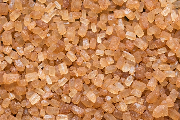 close up of natural brown sugar texture brown sugar background raw sugar top view macro - Рисовая каша с пряностями и орехами