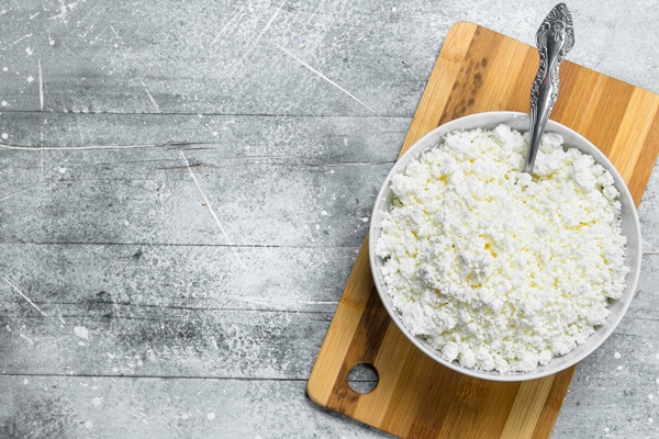 cottage cheese in a bowl with a spoon on a rustic - Творожный кулич