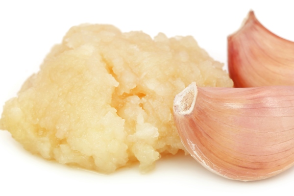 crushed garlic with whole ones over white background - Постное пюре из фасоли и баклажанов
