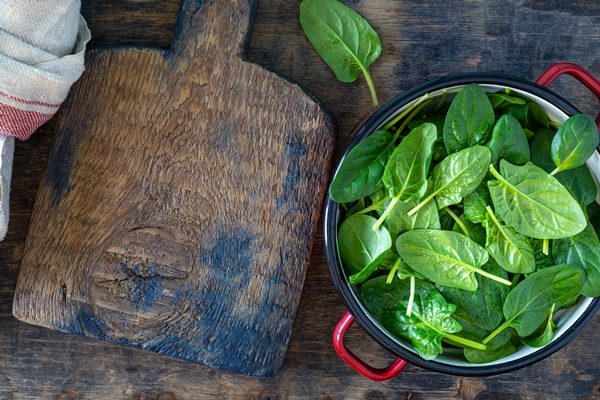 fresh baby spinach leaves in a bowl on a rustic wooden table copy space - Салат с грушей, орехами, шпинатом и тофу