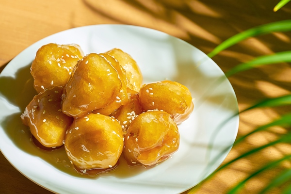 fried bananas in caramel and batter with sesame seeds in a white plate chinese recipe and cuisine - Бананы в карамели