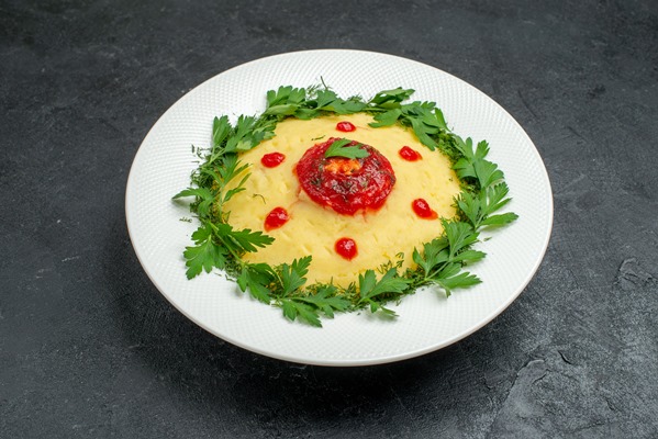 front view mushed potato dish with tomato sauce and greens on dark space - Картошка с зеленью и томатом, постный стол