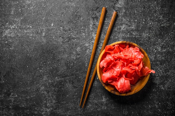 ginger in a bowl with chopsticks on dark rustic background - Тёплый салат из мидий