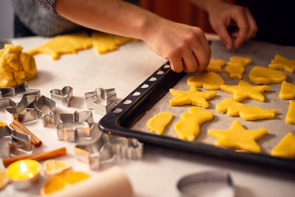 girl putting christmas cookies on the baking sheet - Песочное печенье, постный стол
