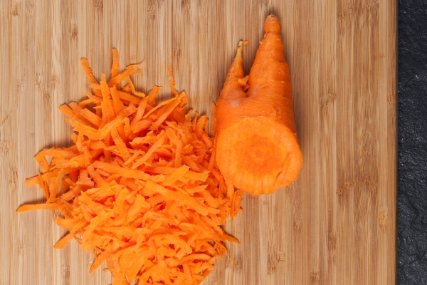 grated carrots on cutting board - Салат из моркови и яблок с сахаром и мёдом