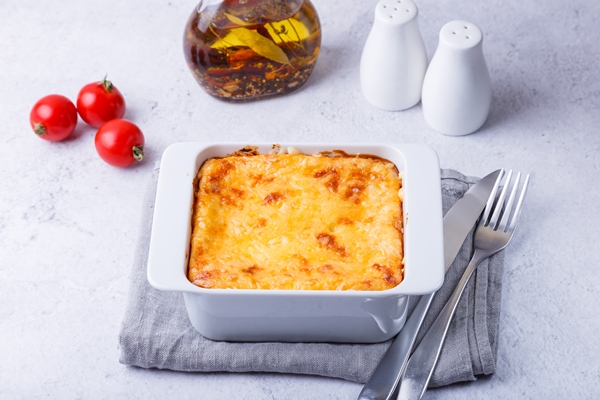 moussaka with meat eggplant tomatoes potatoes bechamel sauce and cheese on a white plate traditional greek dish close up - Постная лазанья с чечевицей