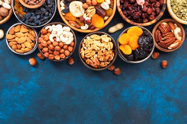 nuts and dried fruits in assortment dry apricots figs raisins walnuts almonds and other blue table background top view copy space - Шоколадный постный пирог