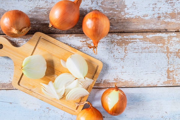 onion cut on a wooden cutting board - Сёмга, запечённая с луком и картофелем, постный стол