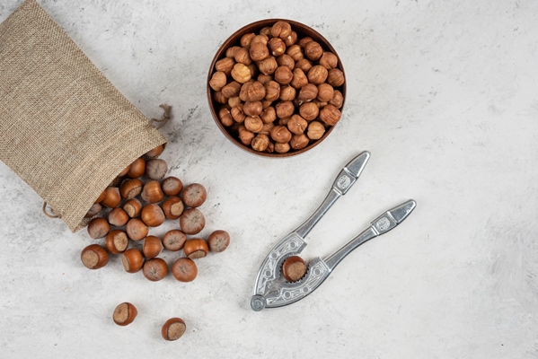organic shelled and kernels of hazelnuts in burlap with cracking tool - Рождественское ореховое печенье