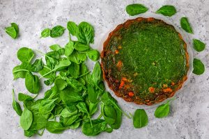 pie with fish and spinach on a light stone background - Киш с сёмгой и шпинатом постный