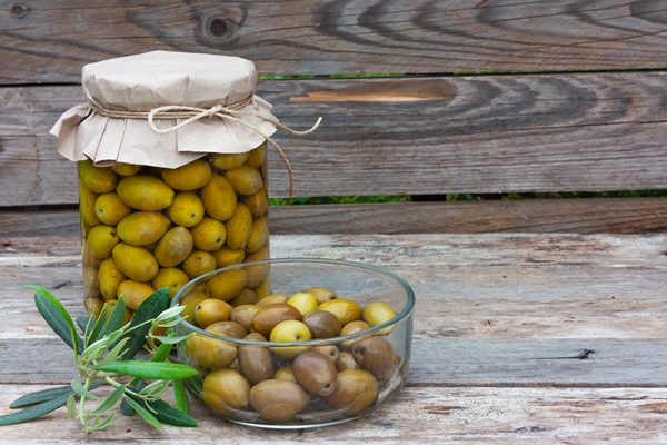 preserved fermented olives in glass jar and bowl on wooden background autumn vegetables canning - Салат с перцем и хлебом