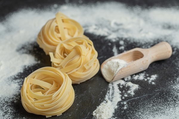 raw nest noodles with flour on black - Грибная лапша без масла