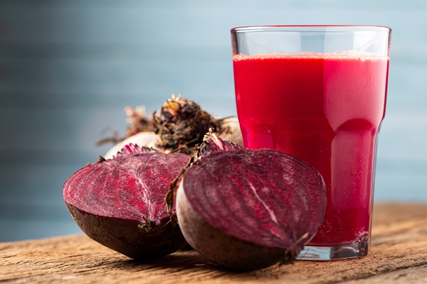 red beet juice in a glass cup on the wooden table - Морс из свёклы