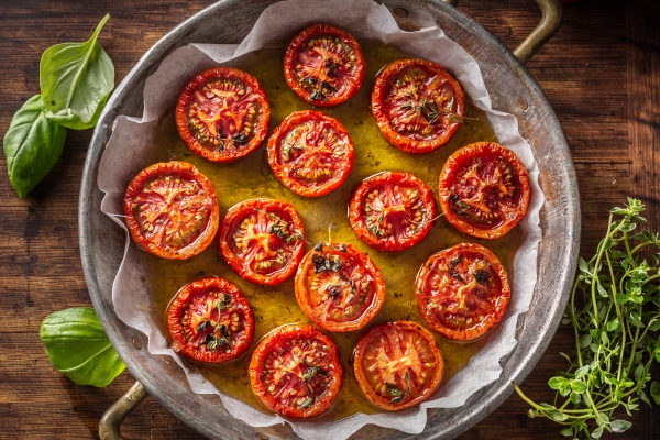 roasted tomatoes with olive oil thyme oregano and basil in pan top of view - Салат из рукколы и креветок