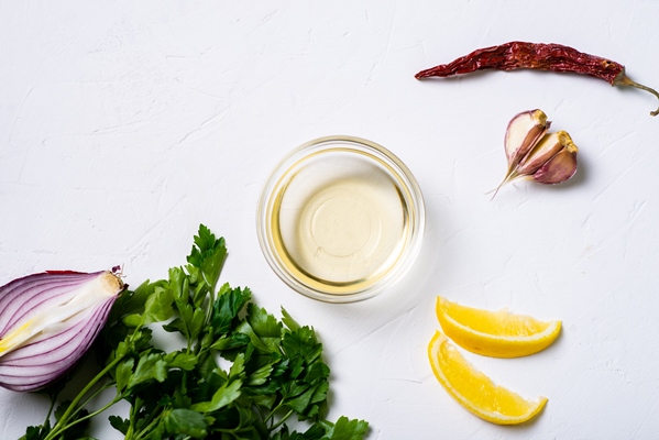sauce preparation lemon olive oil parsley cilantro garlic on a white background - Лобиани