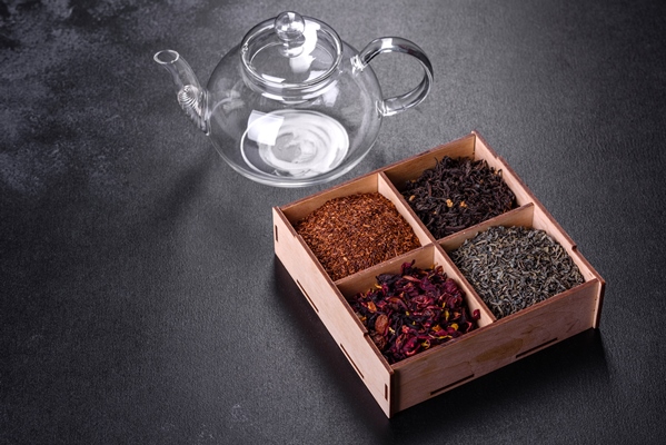 several kinds of dry black tea with bergamot rooibos green and frame in a wooden box on a black concrete background - Постный кекс с черносливом