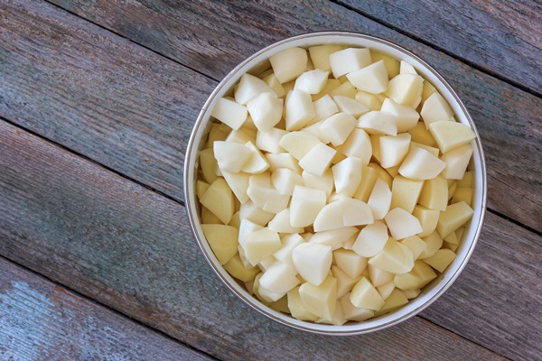sliced pieces of raw potatoes in a bowl - Постный картофель, тушённый с фасолью