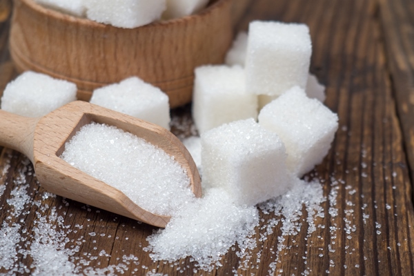 stack of sugar cubes and granulated sugar in a wooden scoop - Рождественское ореховое печенье