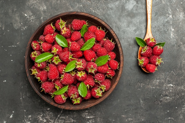 top view fresh red raspberries inside brown plate on grey background - Чай с малиной
