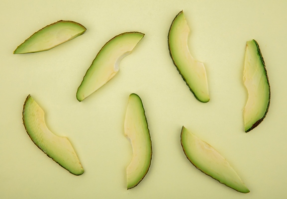 top view of fresh and delicious avocado slices isolated on light green - Постные тако с фасолью и овощами