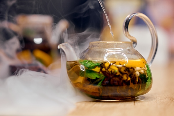 transparent kettle filled with hot water stands in smoke high quality photo - Чай из орегано (душицы)