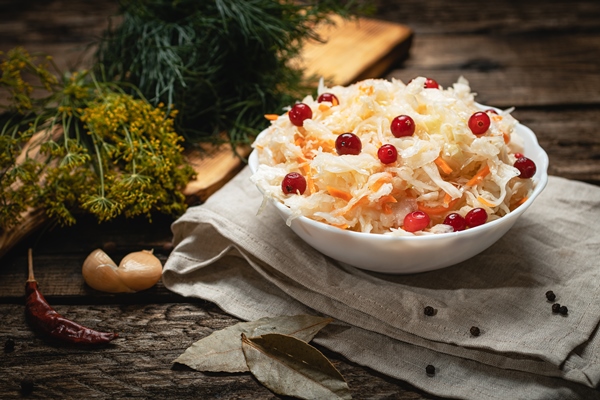 vegan food sauerkraut with cranberries on a wooden surface - Капуста "провансаль"