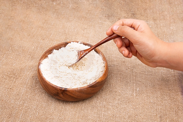 wheat flour in a wooden bowl - Постные ягодные оладьи