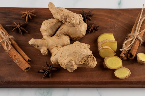 whole and sliced ginger on a piece of wood - Постный кекс с черносливом