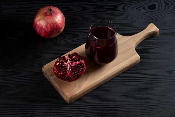 a glass cup of pomegranate juice on wooden board - Гранатовый безалкогольный глинтвейн с яблоком
