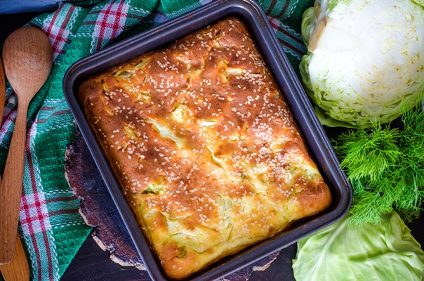 baked pie of young with cabbage and wooden spoon - Наливной пирог с капустой