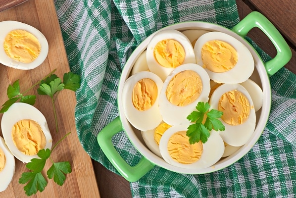 boiled eggs in a bowl decorated with parsley leaves - Фаршированные яйца с крабовыми палочками