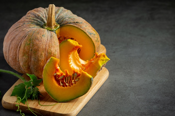 chopped raw pumpkin put on wooden cutting board - Суп-пюре из тыквы c картофелем и молоком