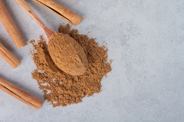 cinnamon sticks and blended powder in a wooden spoon - Горячий шоколад-пудинг
