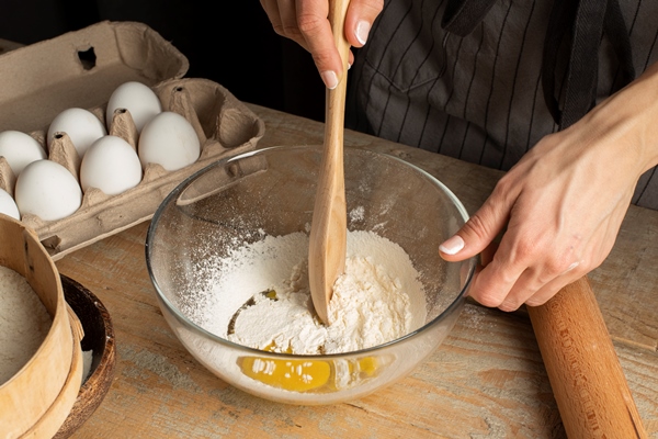 close up hand mixing flour and egg - Бульон с пельменями