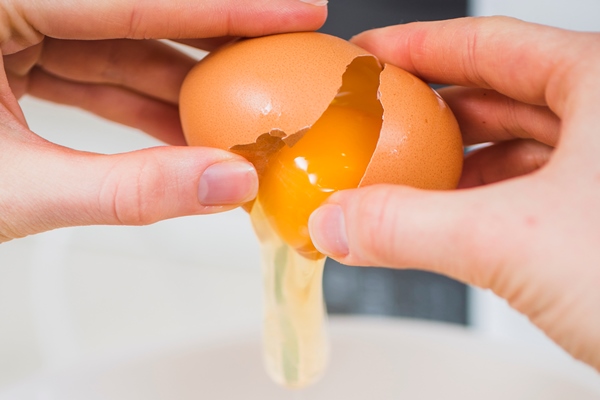 close up hands breaking egg - Котлеты, фаршированные яйцом