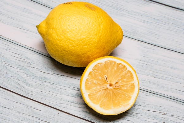 closeup of a lemon on a wooden table - Яблочный глинтвейн с изюмом и лимоном