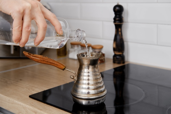 closeup view of man pouring water into cezve with ground coffee - Кофе с лимоном