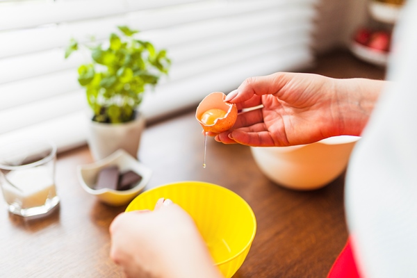 crop woman putting raw eggs into bowl - Яйца "Орсини"