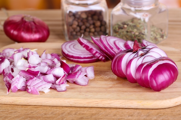 cut onion on cutting board on wooden background - Фриттата с картофелем