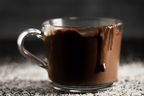 delicious melted chocolate in a transparent cup - Пряный миндальный горячий шоколад