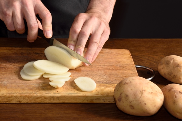 detallle of a chef slicing potatoes - Щи из свежей капусты на мясном бульоне