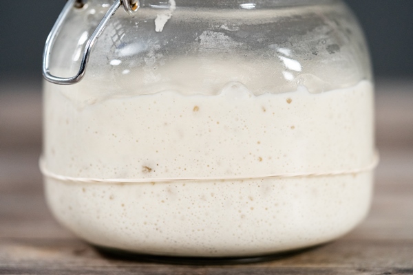 feeding sourdough starter in a glass mason jar for baking artisan bread - Баурсаки