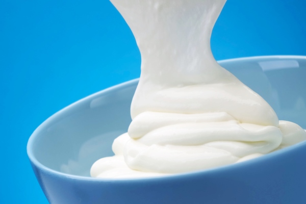 flowing fresh greek yogurt on blue background whipped sour cream - Драники на сметане