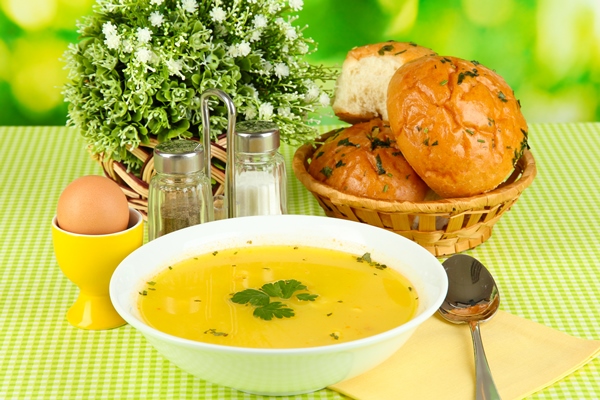 fragrant soup in white plate on green tablecloth on natural background closeup - Бульон с сельдереем