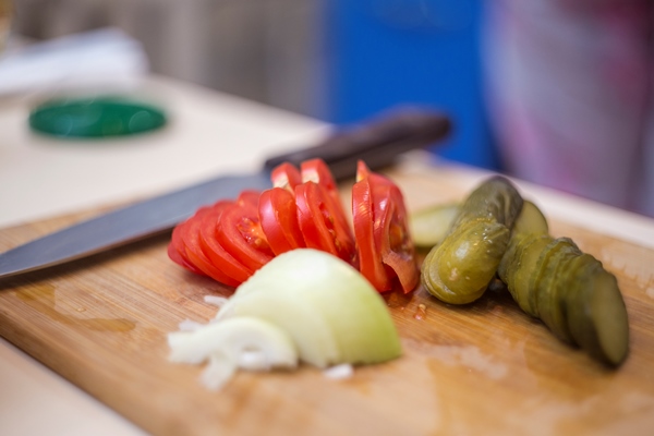 fresh tomatoes pickles onions on a cutting board sliced vegetables closeup - Сборная мясная солянка