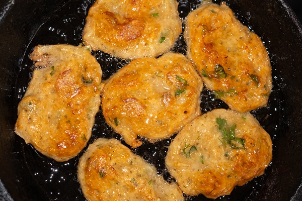 fried potato pancakes in a pan top view closeup - Драники с луком, сыром и чесноком