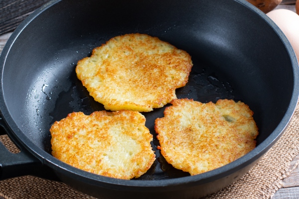 frying pan with fried potato patties vegetable fritters latkes draniki - Драники с мукой, луком и яйцом